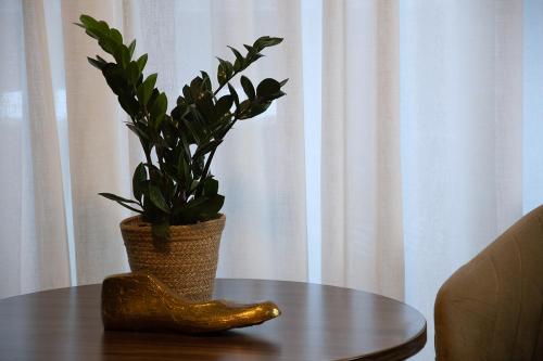 a table with a plant and a vase on it at Landhotel Wolfschlugen in Wolfschlugen