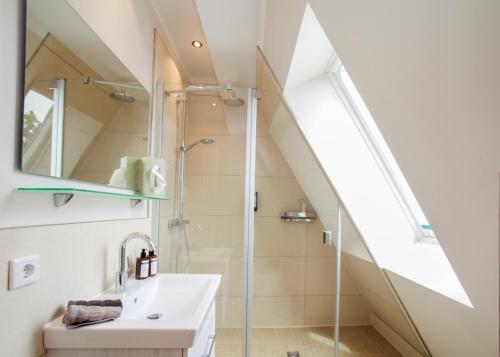 uma casa de banho com um chuveiro e um lavatório. em Haus Vier Jahreszeiten em Wangerooge