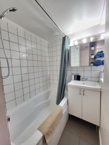 a bathroom with a tub and a sink and a shower at Sunshine Suite in Vancouver