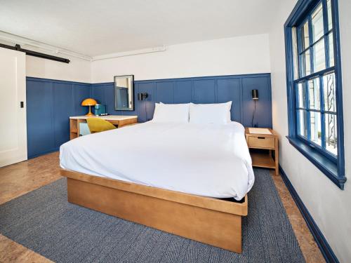 a bedroom with a large bed with blue walls at Bardstown Motor Lodge in Bardstown