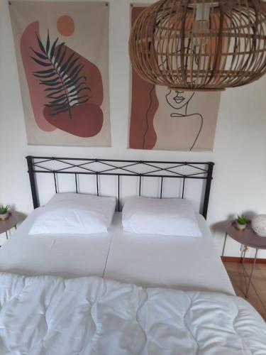 a bedroom with a white bed with two pillows at Waterhuis Friesland in Oudwoude