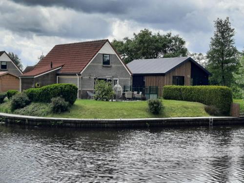 a house next to a body of water at Waterhuis Friesland in Oudwoude