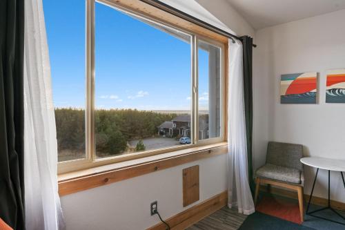 a room with a large window with a chair and a table at Adrift Hotel in Long Beach
