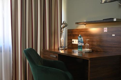a desk with a lamp and a chair in a room at Landhotel Wolfschlugen in Wolfschlugen