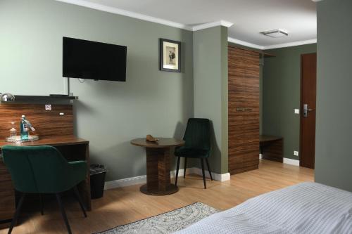 a bedroom with a bed and a desk and a television at Landhotel Wolfschlugen in Wolfschlugen