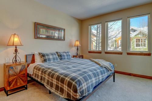 a bedroom with a bed and two windows at New Luxury Pond Villa #558 Hot Tub & Views - 500 Dollars Of FREE Activities & Equipment Rentals Daily in Winter Park