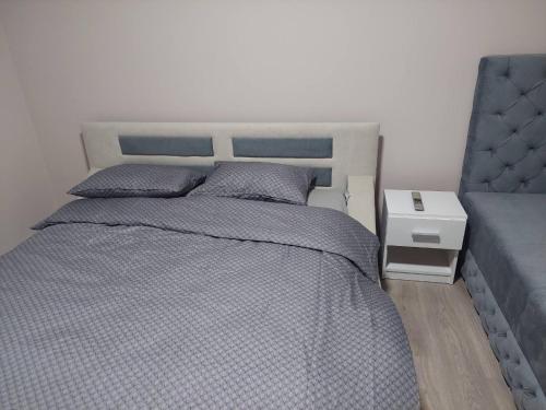 een slaapkamer met een bed met een blauw dekbed bij Rajna in Pirot