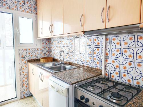 a kitchen with a stove and a sink at Apartamento Diagonal Mar, cerca del Forum y la playa in Barcelona