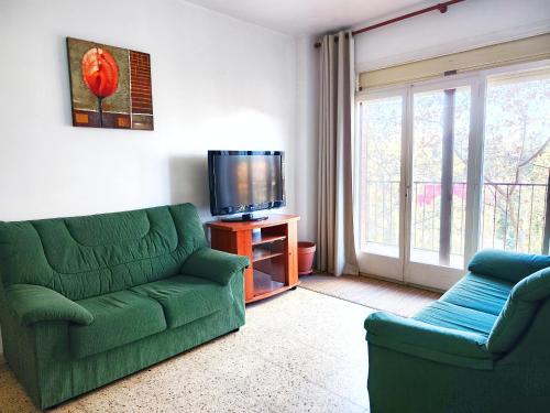 a living room with a green couch and a tv at Apartamento Diagonal Mar, cerca del Forum y la playa in Barcelona