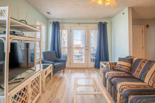a living room with a couch and a bunk bed at Oceanview Condo Near the Boardwalk - Sea Drift Carolina Breezin in Carolina Beach