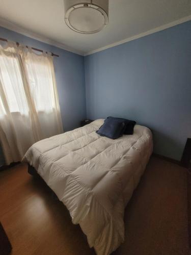 Dormitorio azul con cama con almohada en Departamento Completo y muy buena ubicación en Tandil
