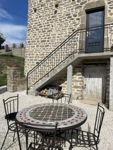 a table and chairs in front of a brick building at Gîte le Ch'armançon in Montigny-sur-Armançon