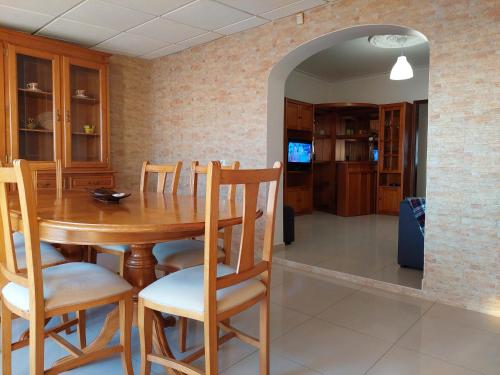 a dining room with a wooden table and chairs at Casa da Alegria - apartamento acolhedor no centro de Olhão in Olhão