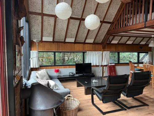 ein Wohnzimmer mit einem Sofa, einem Tisch und Stühlen in der Unterkunft Spacious Holiday Home in Eersel with Open Fire in Eersel
