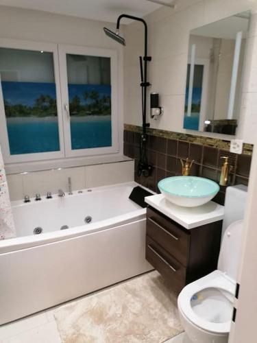 a bathroom with a tub and a sink and a toilet at Luxury Voll möblierte 2 Zimmer Appartement Aarau in Küttigen