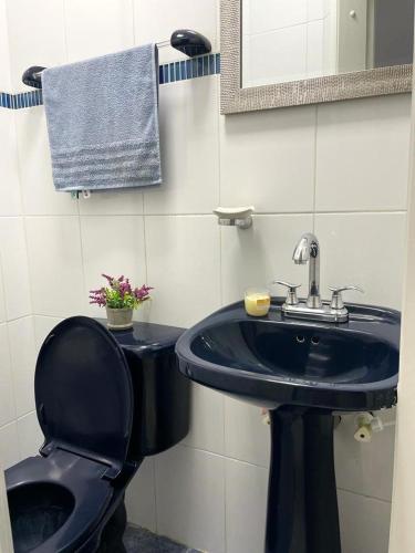 a bathroom with a blue sink and a toilet at Apartamento en Cañaveral in Floridablanca