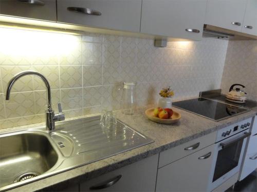 a kitchen with a sink and a bowl of fruit on the counter at Apartment Lea in Maranza