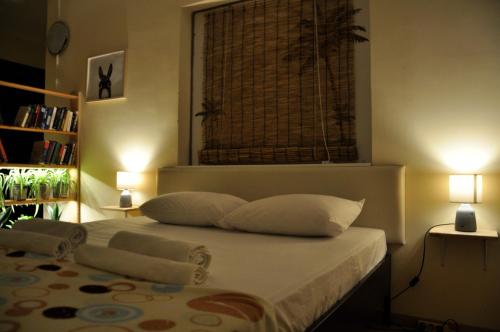 una camera da letto con un letto con due cuscini e una finestra di Funky Nest - A cozy apartment in Zipari a Città di Kos