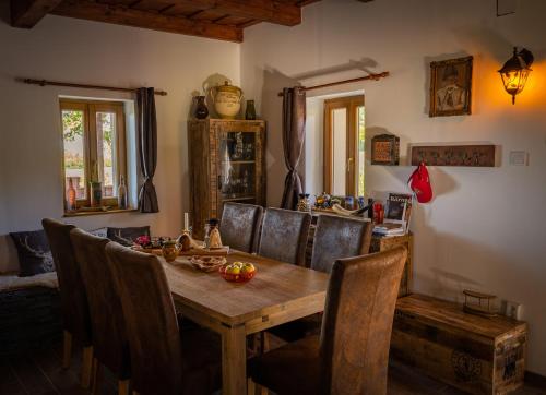 uma sala de jantar com uma mesa de madeira e cadeiras em Kispince Wellness Borbirtok em Böhönye