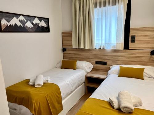 two beds in a room with a window at ELS 4 PICS in Puigcerdà