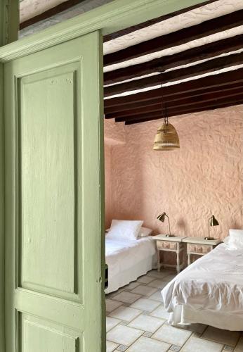 a bedroom with two beds and a door open at Sansofi Guesthouse in San Miguel de Abona