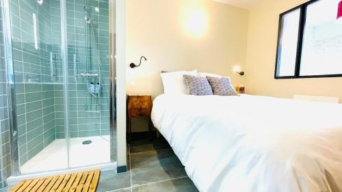 a bedroom with a bed and a glass shower at Voiron centre, grande terrasse, parking, calme in Voiron