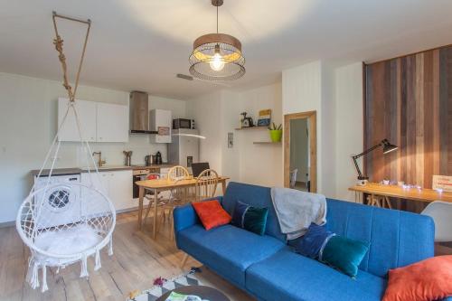 un salon avec un canapé bleu et une cuisine dans l'établissement Paul Janet, à Grenoble