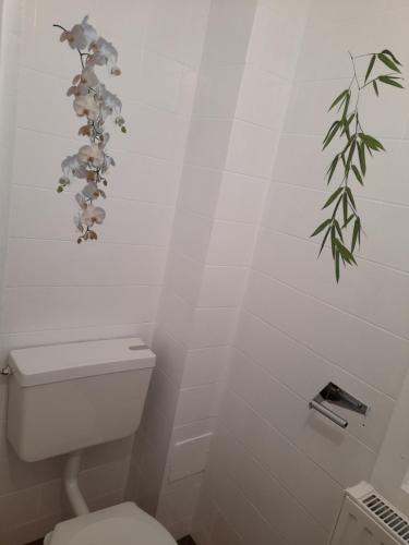 a bathroom with a toilet and a plant on the wall at Holiday Home Doris in Bad Goisern