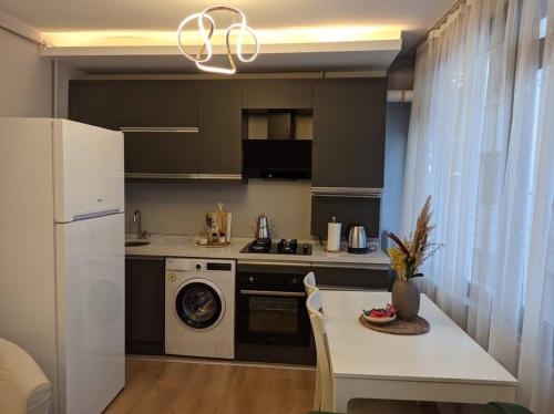 a kitchen with a refrigerator and a table with a washing machine at Modern Apartment in the Heart of the City - Fatih in Istanbul