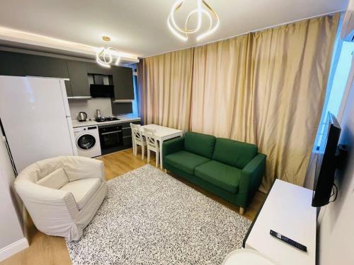 sala de estar con sofá verde y cocina en Modern Apartment in the Heart of the City - Fatih en Estambul