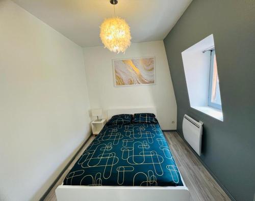 - une chambre avec un lit dans une pièce dotée d'un lustre dans l'établissement L'appartement des Ducs, à Dijon