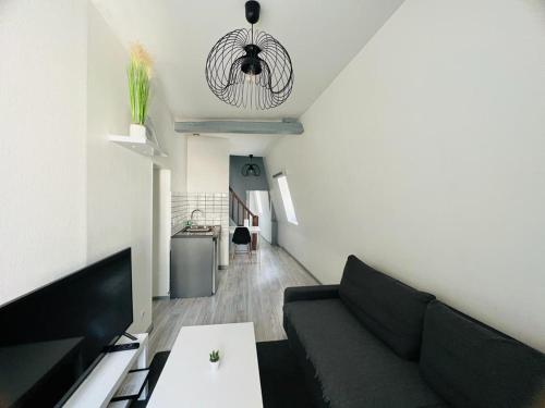 uma sala de estar com um sofá e uma mesa em L'appartement des Ducs em Dijon