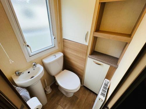 a small bathroom with a toilet and a sink at Luxury 2 Bedroom Caravan LG13, Shanklin, Isle of Wight in Shanklin