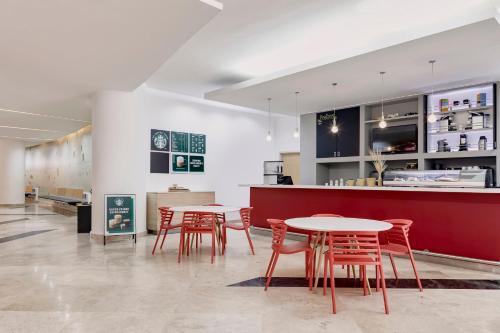 a restaurant with tables and chairs and a counter at Fiesta Inn Insurgentes Viaducto in Mexico City