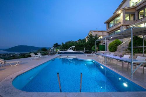 a large swimming pool next to a building at Silencio Villas in Lefkada Town