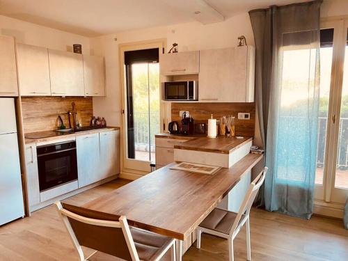 una cocina con mesa de madera y sillas. en Le Marine 4 en Cogolin