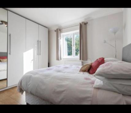 a white bedroom with a large bed and a window at Rainbow Quays in London