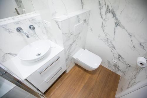 une salle de bain blanche avec un lavabo et des toilettes dans l'établissement Penthouse Exceptionnel vue Mer proche Monaco, à Beausoleil