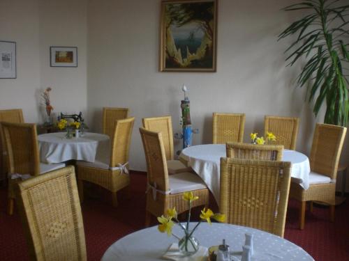 a dining room with tables and chairs with flowers on them at Pension Villa Sophia in Sassnitz