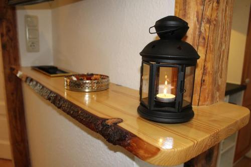 a lantern sitting on a wooden shelf with a candle at Wiesengrund in Bad Harzburg