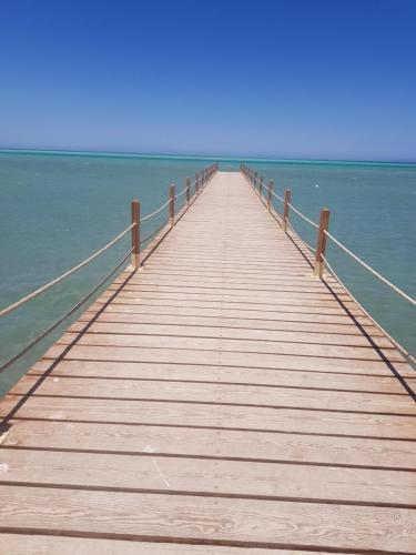 a wooden boardwalk over the water on a beach at Tony's Privy One bed by Red Sea in Hurghada