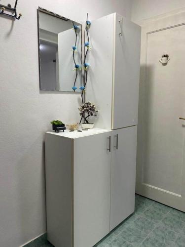 a kitchen with white cabinets and a mirror at Relax Apartments Sarajevo in Sarajevo