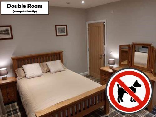 a bedroom with a bed with a dog sign on it at Fountain Cottage Cafe and B&B in Bellingham
