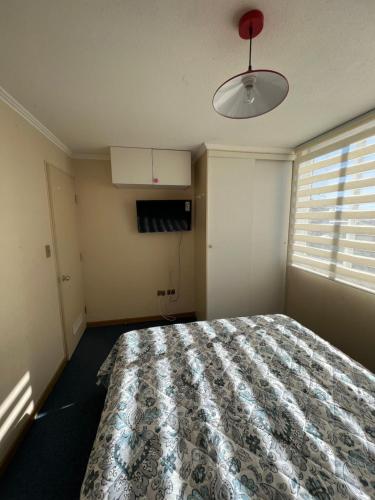 1 dormitorio con cama y ventana en Arriendo departamento, en Temuco