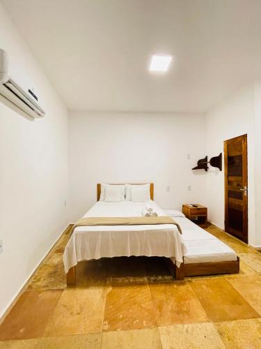 a bedroom with a large bed in a white room at Villa Mar Residence in Jericoacoara