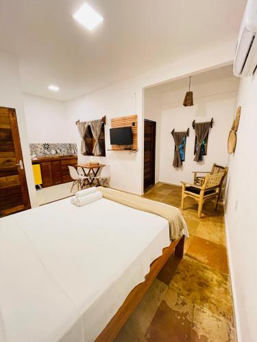 a bedroom with a large bed and a tv at Villa Mar Residence in Jericoacoara