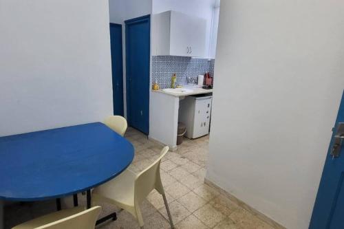 a small kitchen with a blue table and chairs at Studio Pratique bonne proximité in Sfax