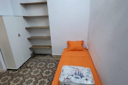 a small hallway with an orange bed in a room at Studio Pratique bonne proximité in Sfax