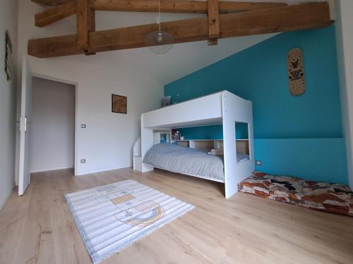 1 dormitorio con cama y pared azul en Domaine Ecoline en Sadirac