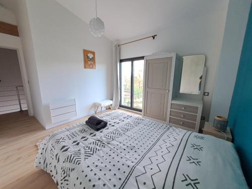 a bedroom with a large bed and a large window at Domaine Ecoline in Sadirac